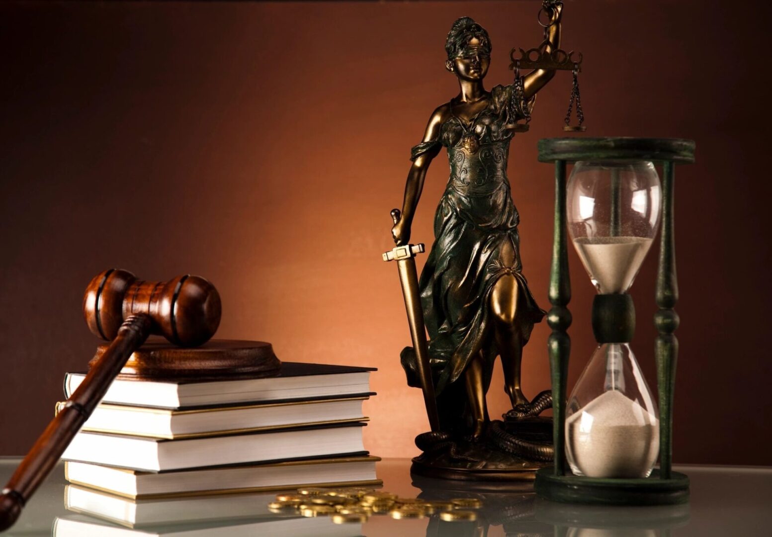 A statue of lady justice, books and hourglass.